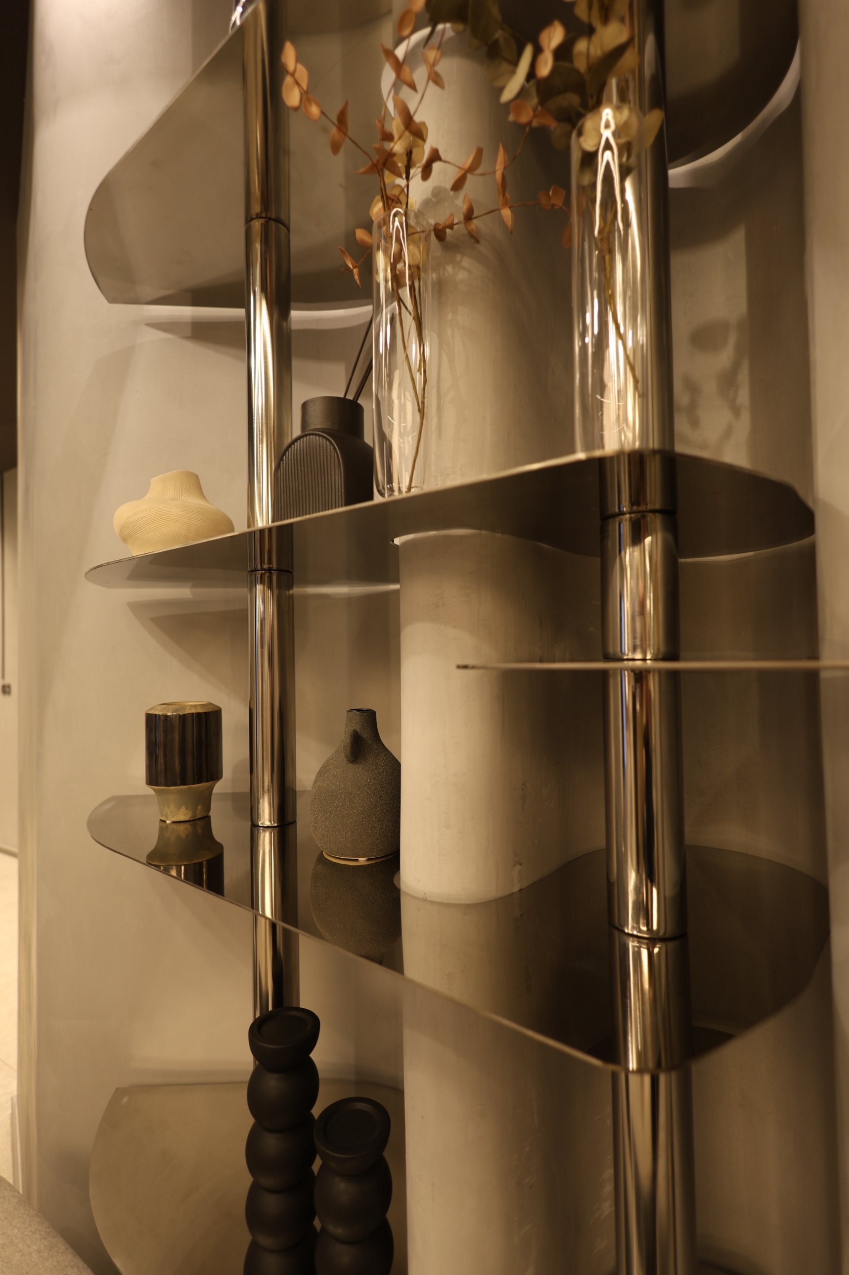 Close-up of leaf-shaped trays on mirror-polished stainless steel uprights at Beauty Time