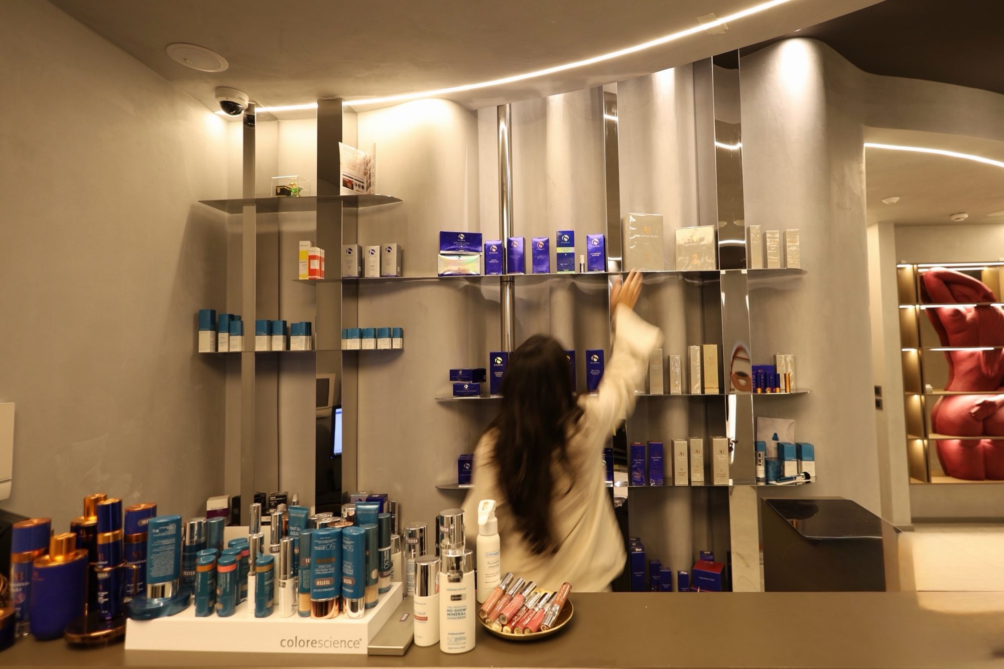 Reception desk and curved retail wall in polished stainless steel at Beauty Time