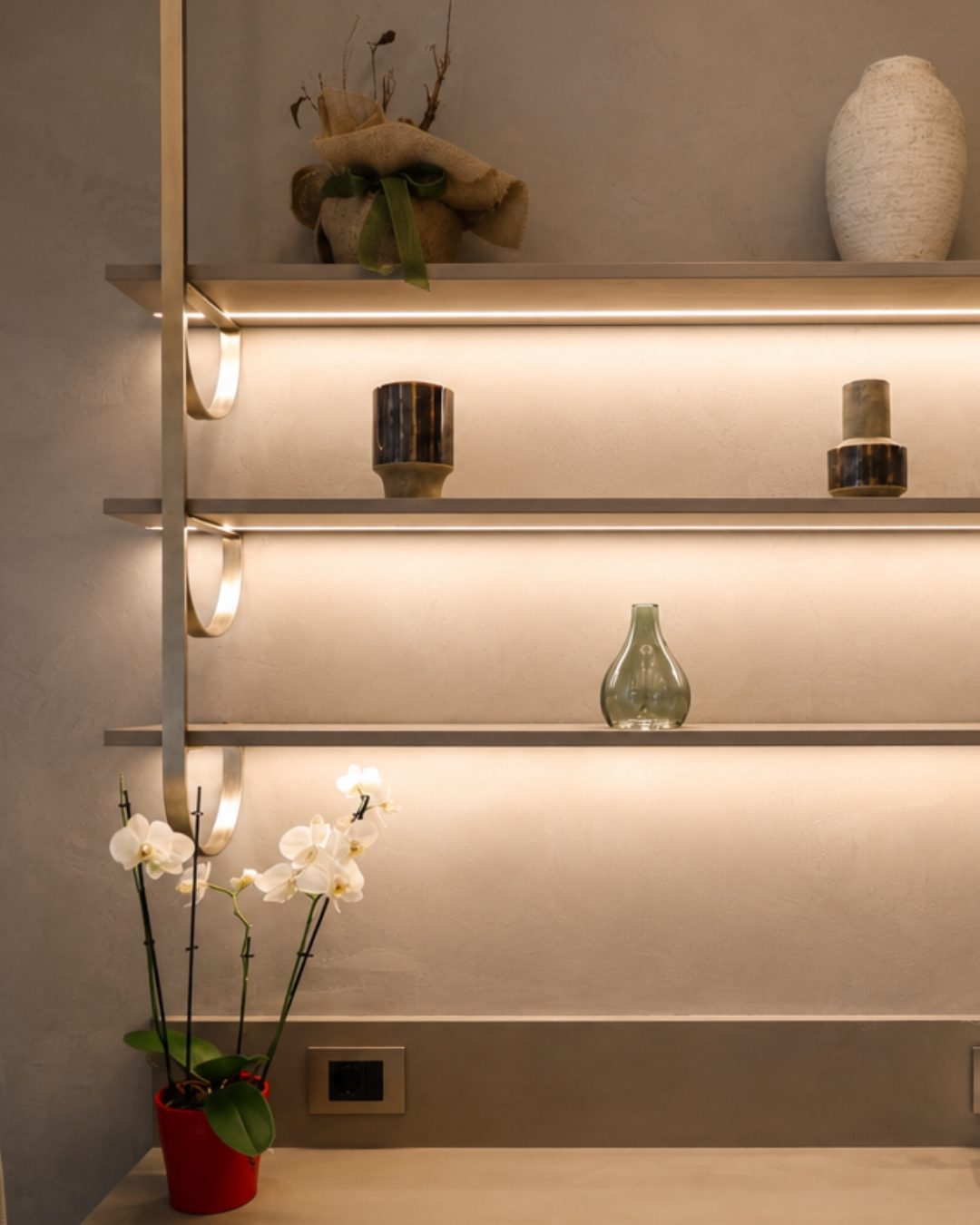 Detail of a lit steel shelf with a looped bracket in a Beauty Time treatment room
