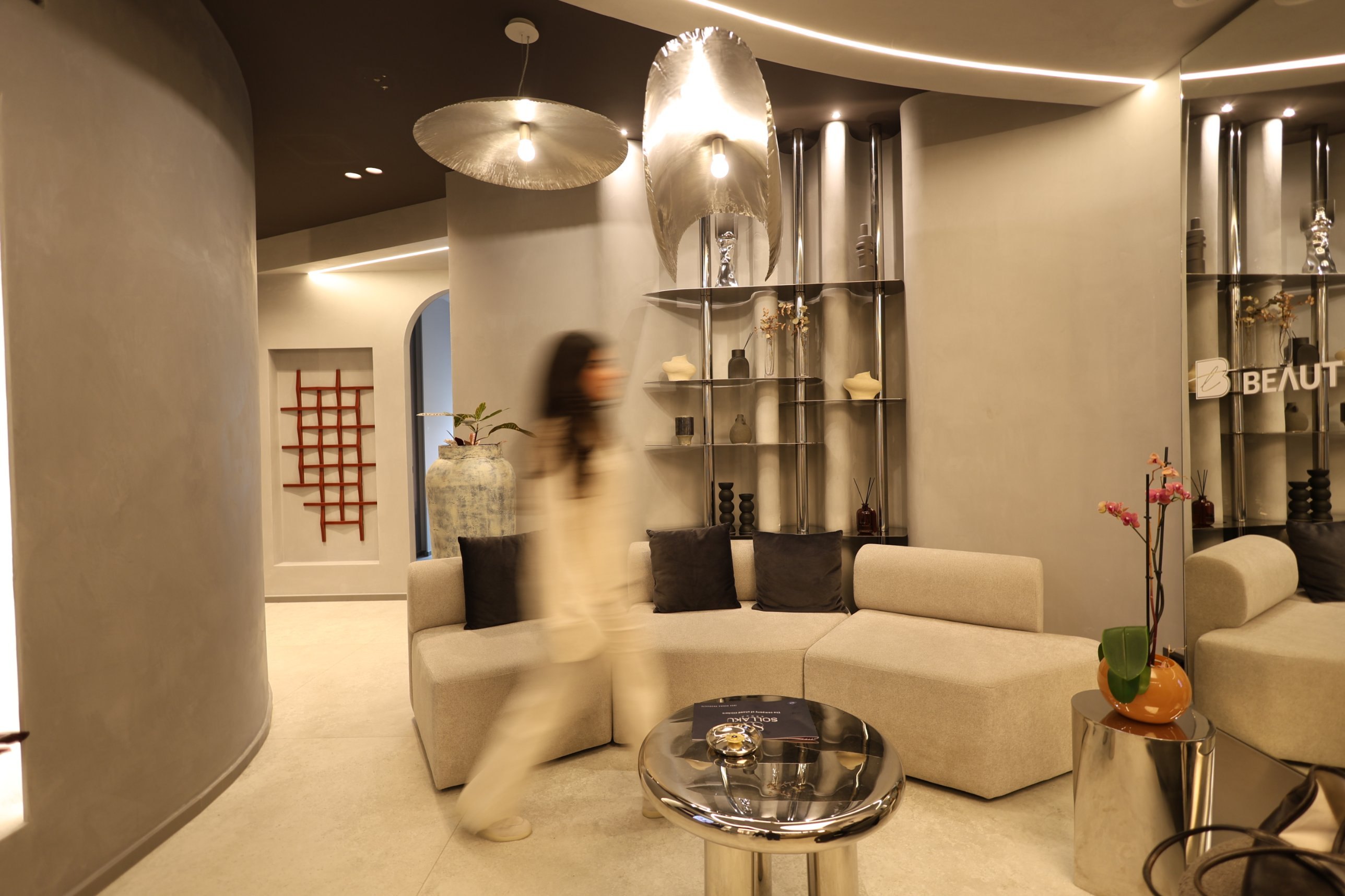 Visitors moving through the Beauty Time waiting room beside the polished stainless steel shelving