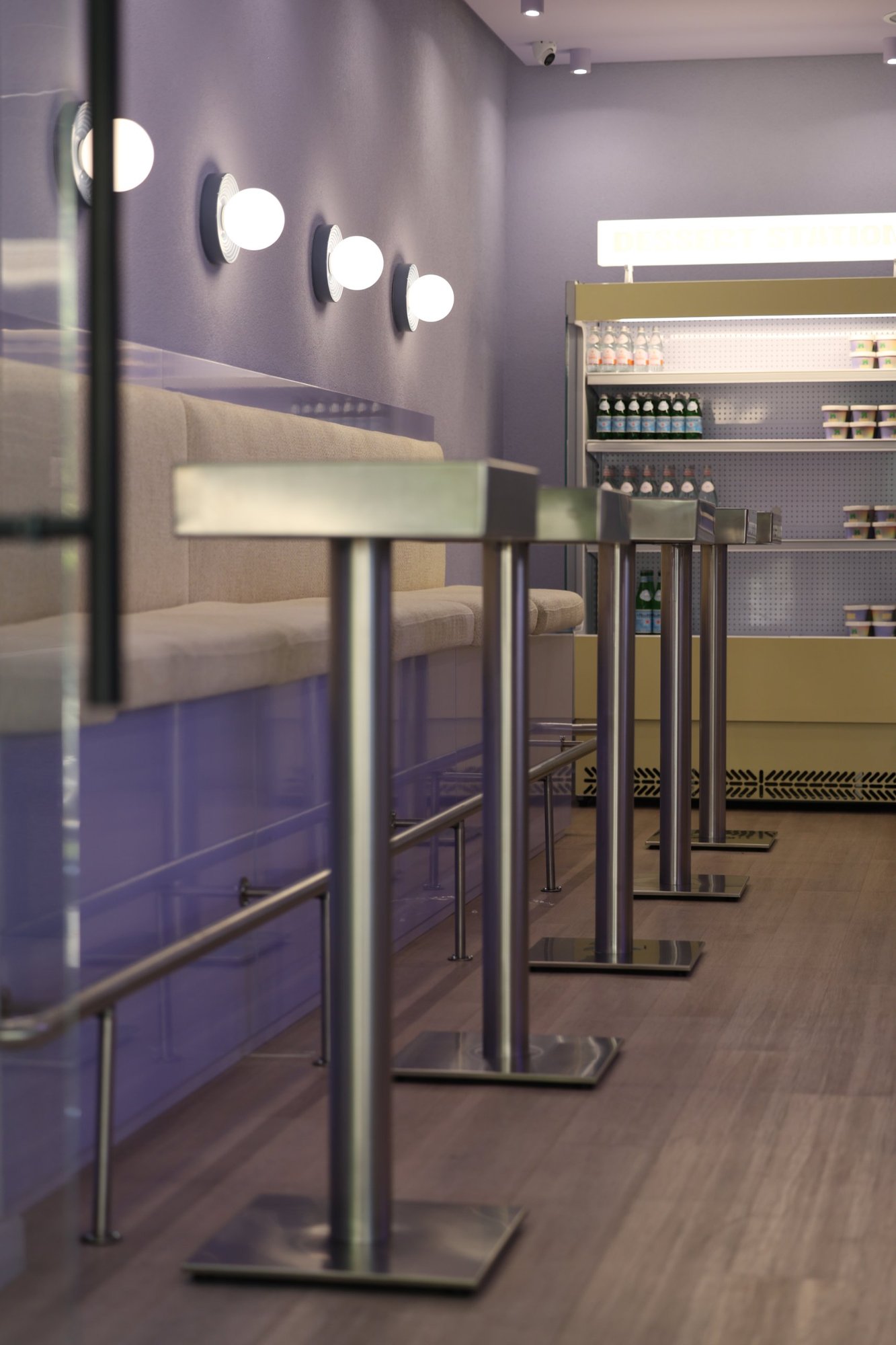 Row of stainless steel high tables at Bloom the Matcha