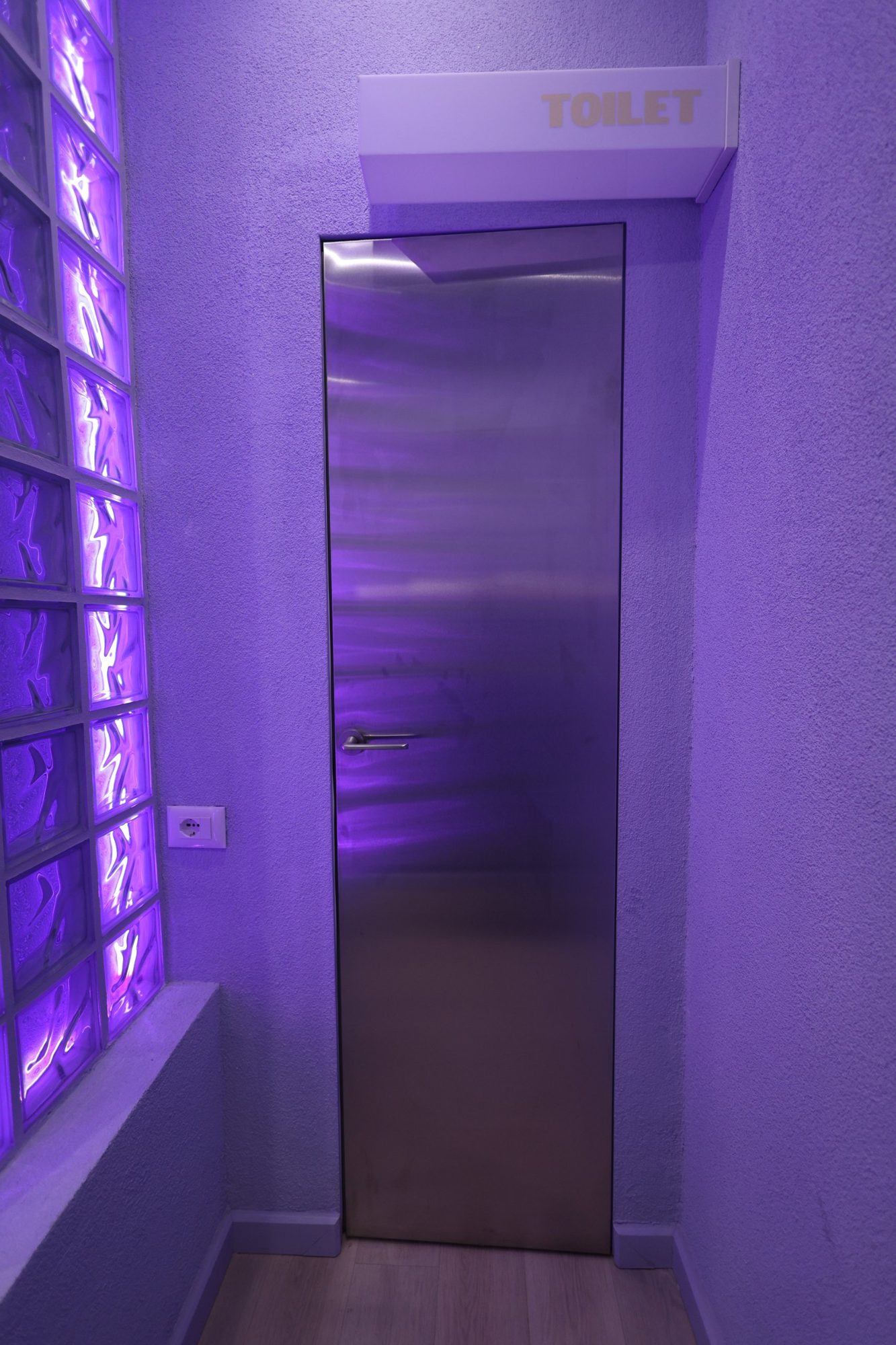 Steel-clad washroom door with continuous surface and integrated hardware at Bloom the Matcha
