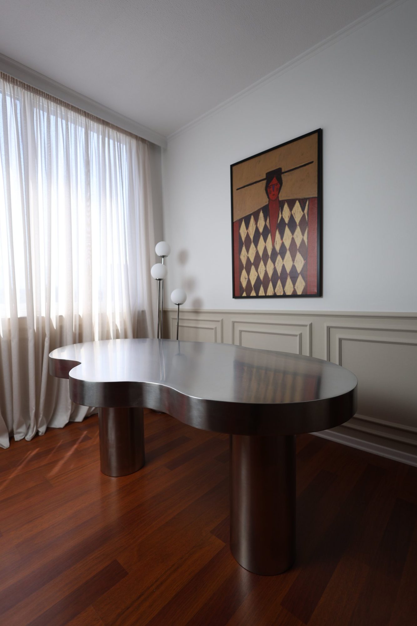 Monolithic stainless steel table with a fluid organic tabletop on cylindrical legs at Door 903