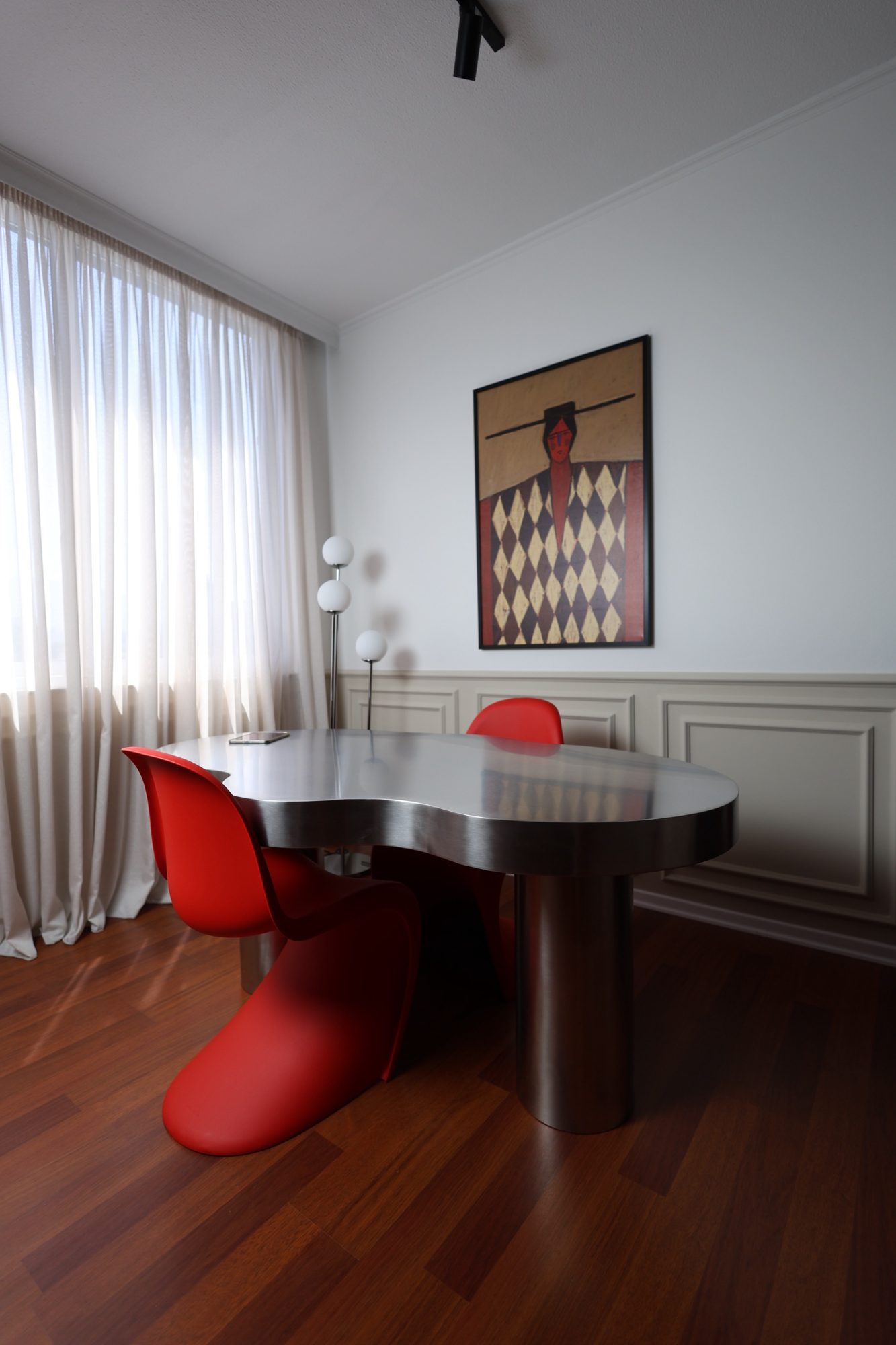 Stainless steel display table surrounded by red chairs at Door 903