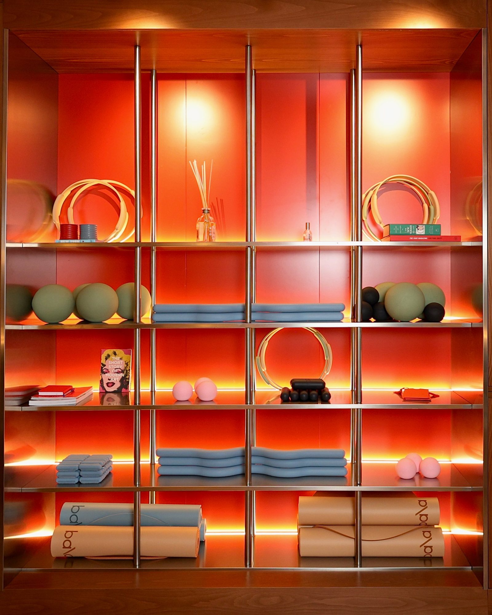 Front view of the polished steel grid and backlit trays holding the studio's equipment at La Suite